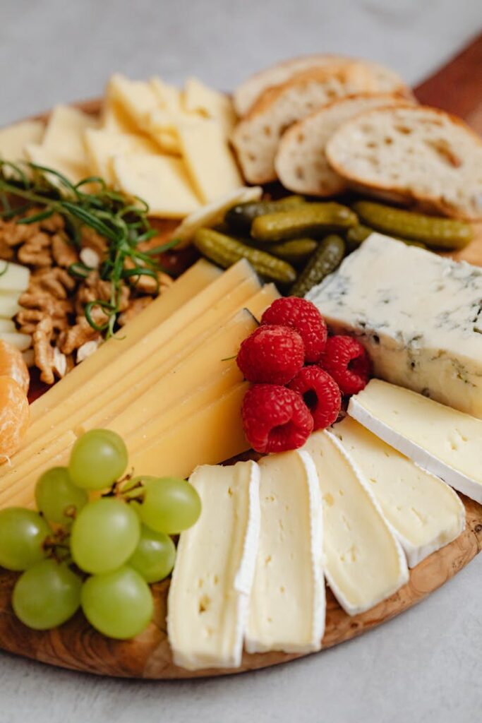 Close-up of a gourmet cheese board featuring various cheeses, fruits, and nuts.